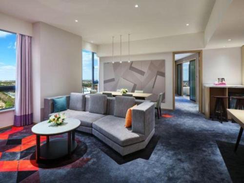 a living room with a couch and a table at Q Hotel Shanghai Pudong in Shanghai