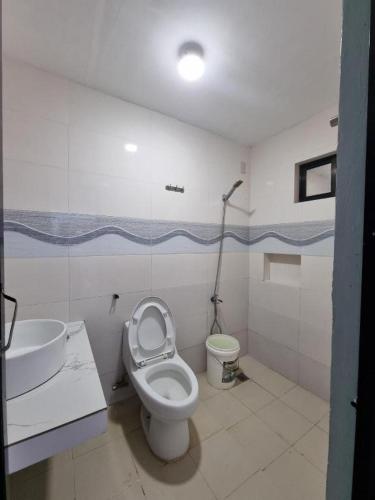 a bathroom with a toilet and a sink at Yemaya de Laiya powered by Cocotel in Batangas City