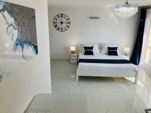 a bedroom with a bed and a clock on the wall at Apartamenty Lux Chorzów in Chorzów