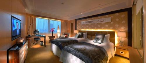 a hotel room with two beds and a television at Radegast Hotel CBD in Beijing