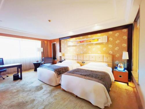 a hotel room with two beds and a desk at Radegast Hotel CBD in Beijing