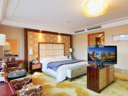 a bedroom with a bed and a flat screen tv at Radegast Hotel CBD in Beijing