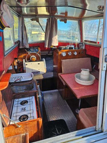 a kitchen with a stove and a table in a boat at bateau tinkerbell in Labastide-dʼAnjou