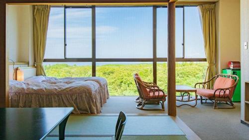 a bedroom with a bed and a large window at Oga Seiko Grand Hotel in Oga