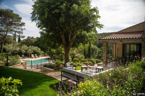 un jardin avec une piscine et une maison dans l'établissement À Font Aubarne, à Nîmes