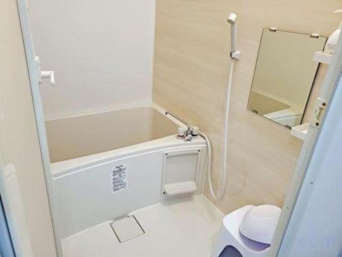 a small bathroom with a toilet and a mirror at Oga Seiko Grand Hotel in Oga