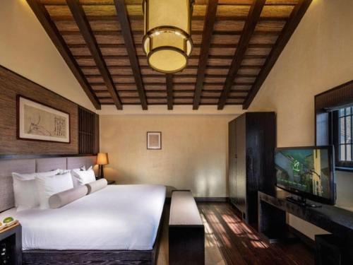 a bedroom with a bed and a flat screen tv at Hotel Dayu Kaiyuan in Shaoxing