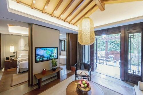 a living room with a room with a bed and a television at Hotel Dayu Kaiyuan in Shaoxing