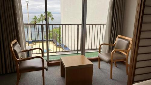 a hotel room with a balcony with a view of the beach at Hamakan Hotel in Unzen