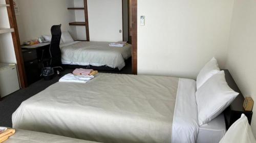 a hotel room with two beds and a mirror at Hamakan Hotel in Unzen