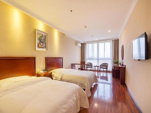 une chambre d'hôtel avec deux lits et une télévision à écran plat dans l'établissement GreenTree Inn Xuzhou High Speed Railway Zhangqian Square Business Hotel, à Xuzhou