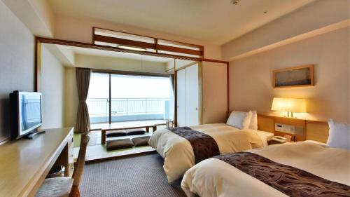 a hotel room with two beds and a television at Hotel Harvest Nankitanabe in Tanabe