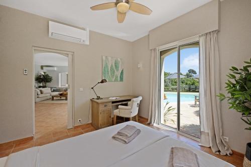 une chambre avec un lit, un bureau et une fenêtre dans l'établissement Villa Cigales, à Roquebrune-sur Argens