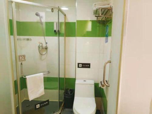 a green and white bathroom with a toilet and a shower at 7 Days Inn Changchun Zhengyang Street Changchun Park Branch in Changchun