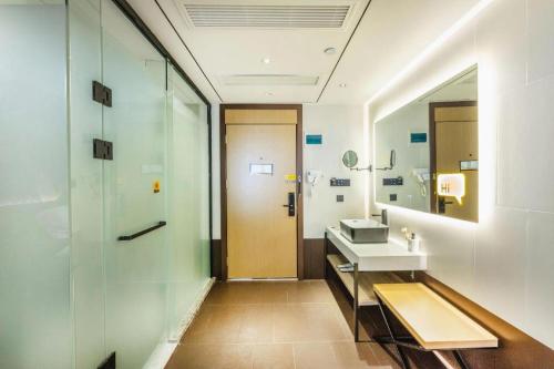 a bathroom with a sink and a mirror at IU Hotel Wujiang Huadong Business City Tongli in Suzhou
