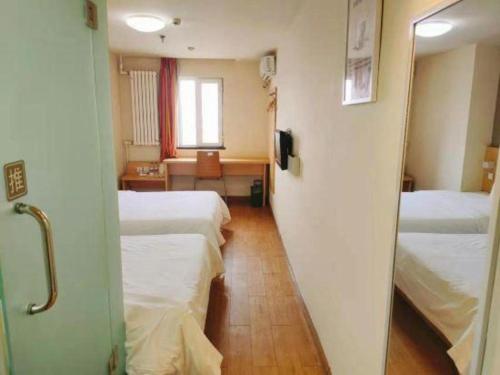 a hospital room with two beds and a window at 7 Days Inn Changchun Zhengyang Street Changchun Park Branch in Changchun