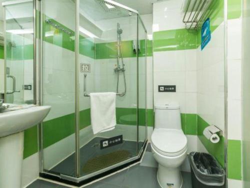 a green and white bathroom with a toilet and a shower at 7 Days Inn Changchun Zhengyang Street Changchun Park Branch in Changchun