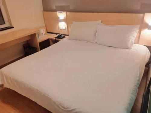 a large white bed in a hotel room at 7 Days Inn Changchun Zhengyang Street Changchun Park Branch in Changchun