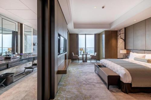 a bedroom with a king sized bed and a bathroom at Golden Eagle Summit Hotel Kunshan in Suzhou