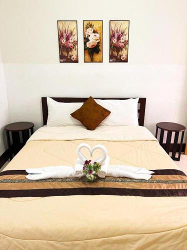 a bed with two white towels on top of it at Rueangrat Hotel in Ranong