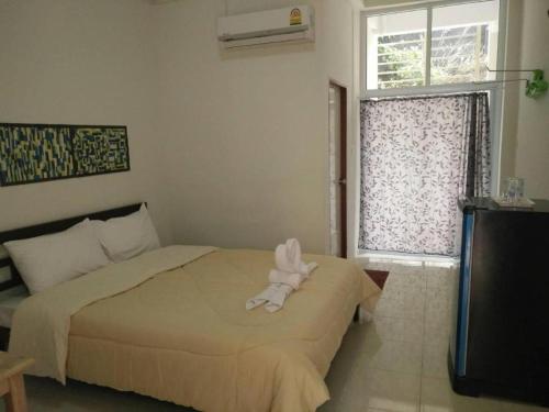 a bedroom with a bed with a stuffed animal on it at Rueangrat Hotel in Ranong