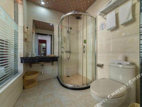 a bathroom with a shower and a toilet and a sink at GreenTree Inn Yancheng Dongtai Railway Station Beihai East Road Express Hotel in Xintuan