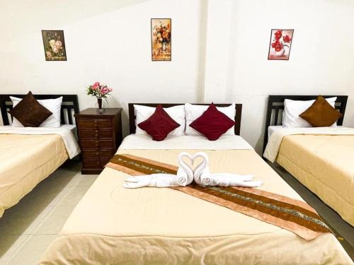 a hotel room with two beds with bows on them at Rueangrat Hotel in Ranong