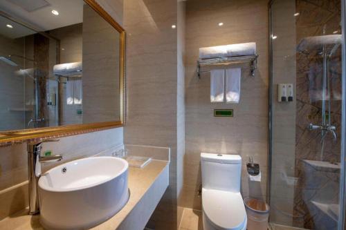 a bathroom with a sink and a toilet and a shower at Vienna Hotel Jiangsu Danyang Railway Station in Zhenjiang