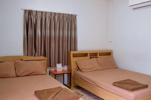 une chambre avec deux lits et une fenêtre dans l'établissement NK garden Hotel @Suratthani Airport, à Surat Thani