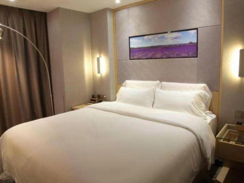 a large white bed in a hotel room at Lavande Hotels Suzhou Railway Station in Suzhou