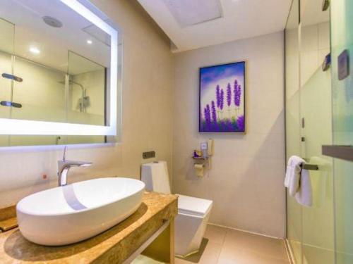 a bathroom with a white sink and a mirror at Lavande Hotels Suzhou Railway Station in Suzhou