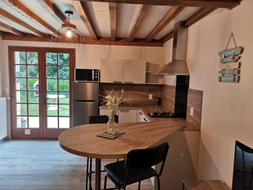 una cucina con un tavolo di legno e una sala da pranzo di Domaine Le Manège - Gite Le Tilleul, près d'Etretat a Sainte-Marie-au-Bosc