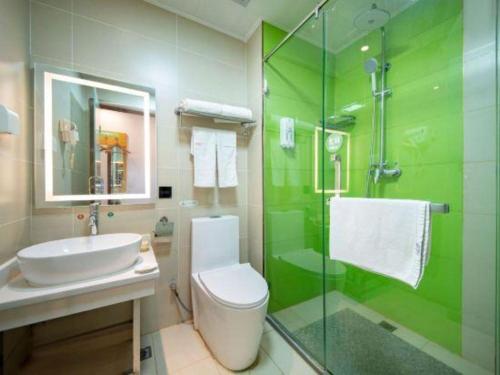 a bathroom with a toilet and a sink and a shower at GreenTree Inn Huayin Huashan Town Huashan Scenicspot Express Hotel in Huayin