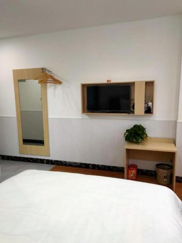 a bedroom with a bed and a flat screen tv at 7 Days Inn·Taixing Wenchang Road in Taixing
