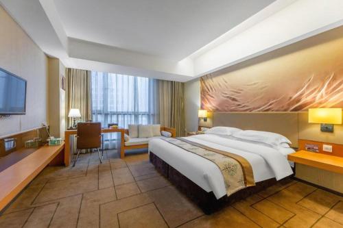 ein Hotelzimmer mit großem Bett und Schreibtisch in der Unterkunft Jinjiang Metropolo Nanchang Honggutan Wanda Plaza in Nanchang