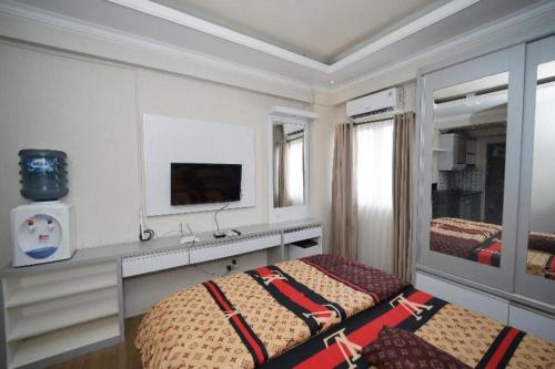 a bedroom with a bed and a sink and a mirror at OYO Living 3091 Apt The Suites Metro By Ananda in Bandung