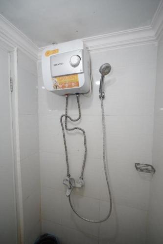a shower in a white bathroom with a shower at OYO Living 3091 Apt The Suites Metro By Ananda in Bandung