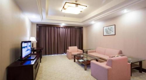 a living room with a couch and chairs and a television at Chaozhou Hotel in Chaozhou