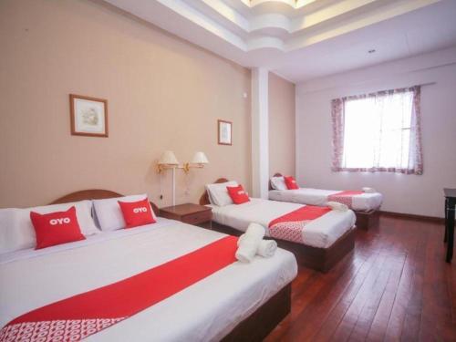 une chambre d'hôtel avec deux lits et une fenêtre dans l'établissement OYO 89537 Fairy Garden Resort, à Kampong Kinasaraban