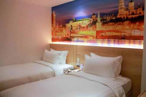 two beds in a hotel room with a picture on the wall at London Hotel in Macau
