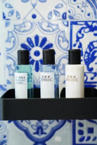a shelf with four bottles of disinfectants on a wall at London Hotel in Macau