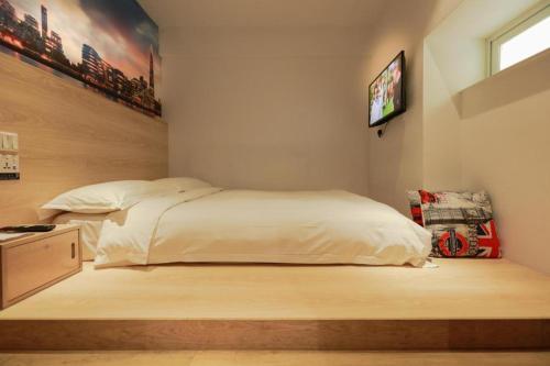 a bedroom with a bed and a tv on the wall at London Hotel in Macau