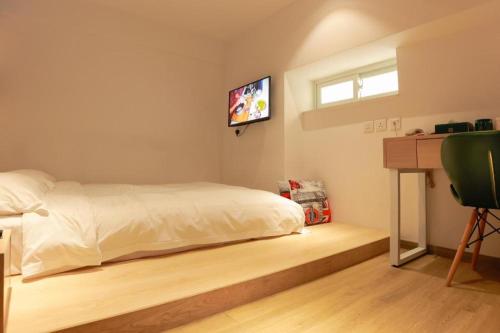 a bedroom with a bed and a television on the wall at London Hotel in Macau