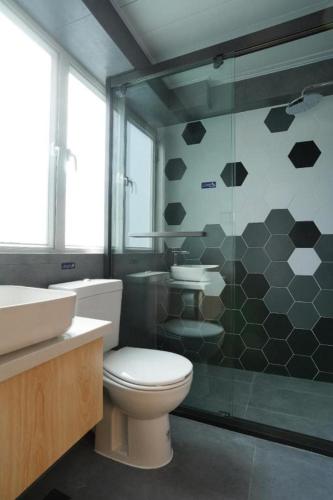 a bathroom with a toilet and a glass shower at London Hotel in Macau