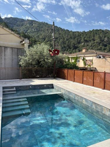 a swimming pool with blue water in front of a house at CAZORLA NATURA - NUEVOS 2025 - 6 Apartamentos Turísticos- in Arroyo Frio