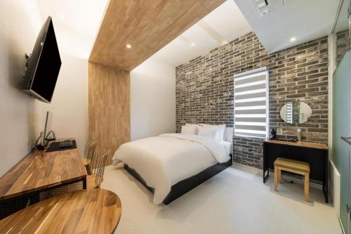 a bedroom with a bed and a brick wall at Crossing Hotel in Seoul