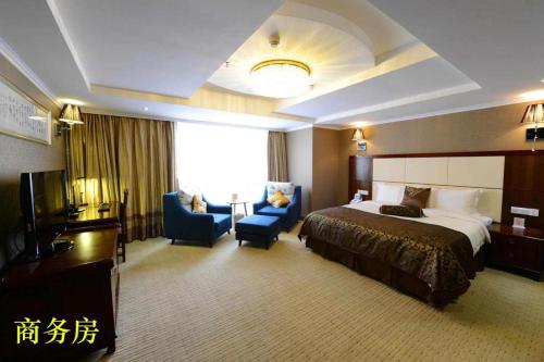 a hotel room with a bed and chairs and a television at Liyuan Hotel in Shenzhen