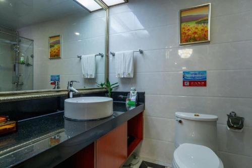 a bathroom with a toilet and a sink and a mirror at Liyuan Hotel in Shenzhen