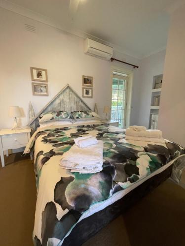 a bedroom with a large bed with a cow blanket at The Castle - Villa by the Sea in Cowes