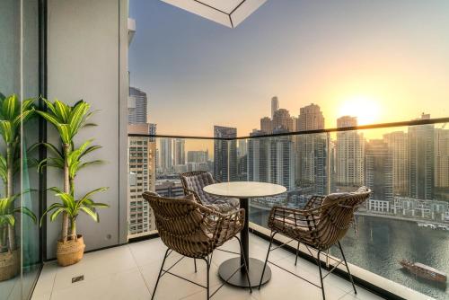 a balcony with a table and chairs and a view of the city at Panoramic Marina 1BR City Skyline Views with Balcony, Pool & Gym Access in Dubai